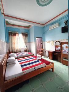 a bedroom with a large bed and a desk at Khách sạn Ngọc Mai 2 in Can Tho