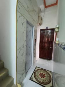 un couloir avec une porte, un tapis et un escalier dans l'établissement Khách sạn Ngọc Mai 2, à Cần Thơ
