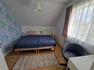 1 dormitorio con 1 cama azul y 1 silla en Goda Apartman Siófok en Siófok