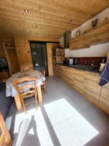 eine Küche und ein Esszimmer in einem Blockhaus in der Unterkunft Studio pour petite famille in Le Grand-Bornand