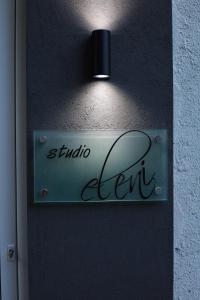 una señal en una pared con una luz en ella en Studio Eleni en Plomari
