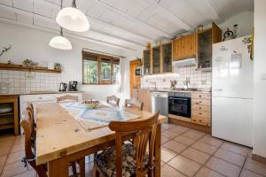 cocina con mesa de madera y nevera blanca en Casa Mariti, en Mont-ral