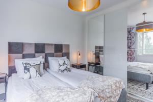 biała sypialnia z 2 łóżkami i wanną w obiekcie City Holiday Apartments 2 w mieście Rovaniemi