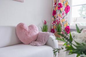 a pink stuffed heart sitting on a white couch at City Holiday Apartments 2 in Rovaniemi