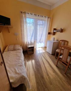 a bedroom with a bed and a large window at Dom Gościnny Roksana in Rewal