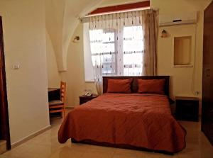 Schlafzimmer mit einem Bett und einem großen Fenster in der Unterkunft Lamar Guesthouse - Hebron in Hebron
