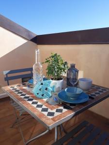 een tafel met een geruit tafelkleed en een fles bij Skyline, Casa Vacanze in Savona