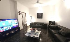 a living room with a couch and a flat screen tv at Bella Vista on Nara Stay 4n each guest get free Day trip Kens Klassic Kombi in Airlie Beach