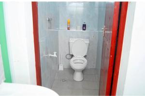 a bathroom with a white toilet in a stall at Emap Homes- Golf studio in Kilifi