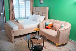 a living room with a couch and a bed and a table at Emap Homes- Golf studio in Kilifi