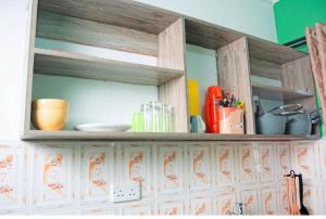 estante de madera con utensilios encima de la cocina en Emap Homes- Golf studio, en Kilifi