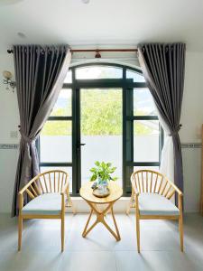 2 Stühle und ein Tisch vor einem Fenster in der Unterkunft Hotel Thuý Nguyễn 