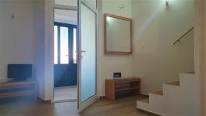 um quarto com um espelho, uma escada e uma porta em Holiday house - Dvori Vlahovici em Opuzen