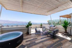 a living room with a jacuzzi tub on a roof at Desert and Sea-penthouse Full Sea view in Eilat