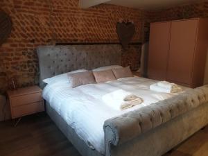 a bedroom with a large bed with towels on it at Luxury barn with hot tub (Dogs Welcome) in Roughton