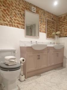 a bathroom with a sink and a toilet and a mirror at Luxury barn with hot tub (Dogs Welcome) in Roughton