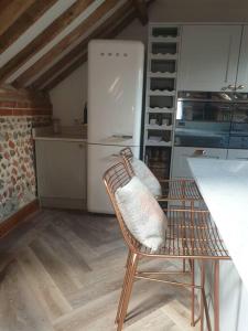 a kitchen with a chair and a refrigerator at Luxury barn with hot tub (Dogs Welcome) in Roughton