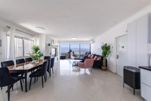 a dining room and living room with a table and chairs at Desert and Sea-penthouse Full Sea view in Eilat