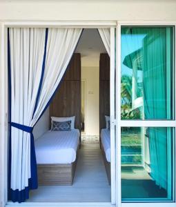 a bedroom with a bed and a sliding glass door at Solesor Kampong Beach Resort in Port Dickson