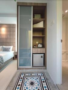 um quarto com uma cama e uma parede de vidro em Solesor Kampong Beach Resort em Porto Dickson
