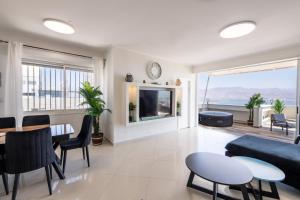 a living room with a couch and a table at Desert and Sea-penthouse Full Sea view in Eilat
