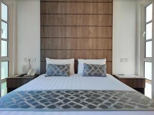 1 dormitorio con 1 cama grande y cabecero de madera en Solesor Kampong Beach Resort en Port Dickson