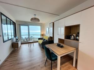 ein Wohnzimmer mit Tisch und Couch in der Unterkunft Charmant T2 en front de mer, 4 pers., ascenseur, garage, Wi-Fi - FR-1-361-383 in Granville