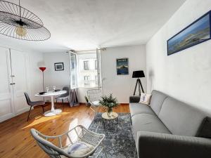 ein Wohnzimmer mit einem Sofa und einem Tisch in der Unterkunft Appartement Granville, 2 pièces, 2 personnes - FR-1-361-428 in Granville