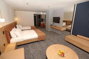 a hotel room with a bed and a television at İnanlar City Hotel in Yomra