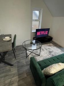 a living room with a green couch and a table at Apartment with Balcony Sea Views with parking - Sleeps 4 in Westcliff-On-Sea