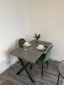 a dining room table with two plates and a plant on it at Apartment with Balcony Sea Views with parking - Sleeps 4 in Westcliff-On-Sea