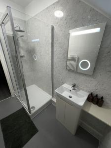 a bathroom with a shower and a sink and a mirror at 34D Genesta Road - Apartment with Balcony Sea Views with parking - Sleeps 4 in Westcliff-On-Sea
