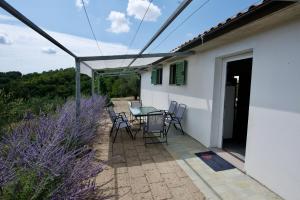 a patio with a table and chairs on a house at Poggio Ferrone in Suvereto