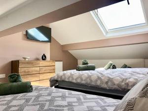 um quarto com 2 camas e uma clarabóia em Home 2 Home Living em Clayton le Moors
