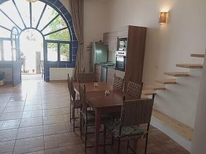 a dining room with a table and chairs and a kitchen at Auberge du Marabout in Sidi Kaouki