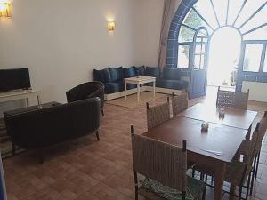 sala de estar con mesa y sofá en Auberge du Marabout, en Sidi Kaouki