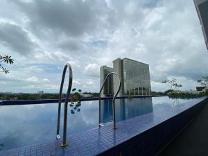 uma piscina do hotel com vista para um edifício em The Yudhistira Tower by Asoka em Kejayan
