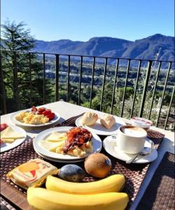 einen Tisch mit Lebensmittelplatten auf einem Tisch mit Aussicht in der Unterkunft Renaissance Tuscany Il Ciocco Resort & Spa in Barga