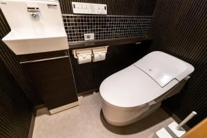 a bathroom with a white toilet and a sink at Oyado Kawaramachi Gojo（御宿 河原町五条） in Kyoto