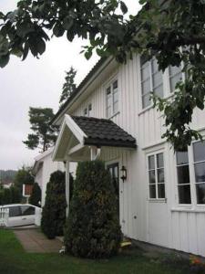 una casa blanca con toldo a un lado. en Cosy flat for 4 persons, en Kristiansand