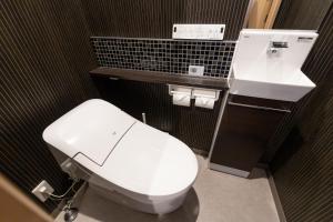 a bathroom with a white toilet and a sink at Oyado Kawaramachi Gojo（御宿 河原町五条） in Kyoto