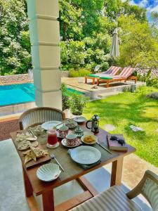 a table with plates of food on it next to a pool at The Jungle Loft Galle in Galle