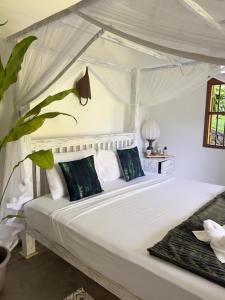 a bedroom with a large white bed with pillows at The Jungle Loft Galle in Galle