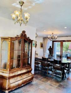 ein Esszimmer mit einem Tisch und einem Kronleuchter in der Unterkunft Cozy house with 3 big bedrooms in Ban Suan