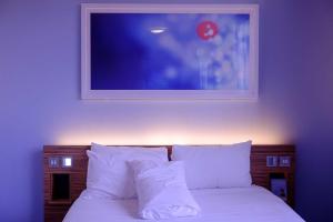 a bed with white pillows and a picture on the wall at POP 80707E K.k Hotel Room & Restaurant in Rewāri