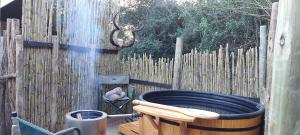 a hot tub in a backyard with a fence at Quatermain's 1920's Safari Camp – Amakhala Game Reserve in Amakhala Game Reserve