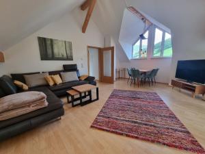 a living room with a couch and a flat screen tv at Kurparkhotel Faißt in Bad Peterstal-Griesbach