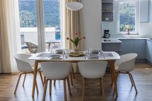 a kitchen and dining room with a table and chairs at Apartment Greba in Grebaštica