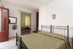 Residence Marina Corta في ليباري: غرفة نوم بسرير ولحاف اخضر