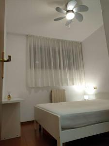 a bedroom with a white bed and a ceiling fan at bilocale in residence CIR 017067-LNI-00151 in Desenzano del Garda